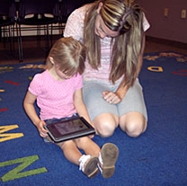 a young girl uses an e-reader
