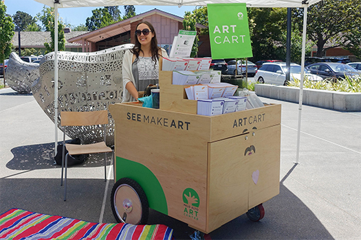 Museum staffer outside with art cart