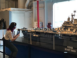 A female educator sitting at a desk in a museum.