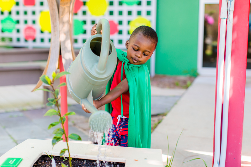 Child watering outdoor plant Mississippi Children's Museum