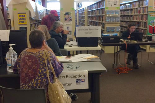 Librarians register volunteers at reception table.