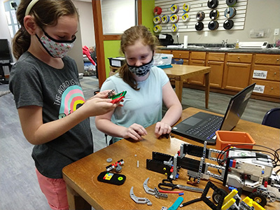 two girls working on the Brimfield Public Library LEGO Robotics Team