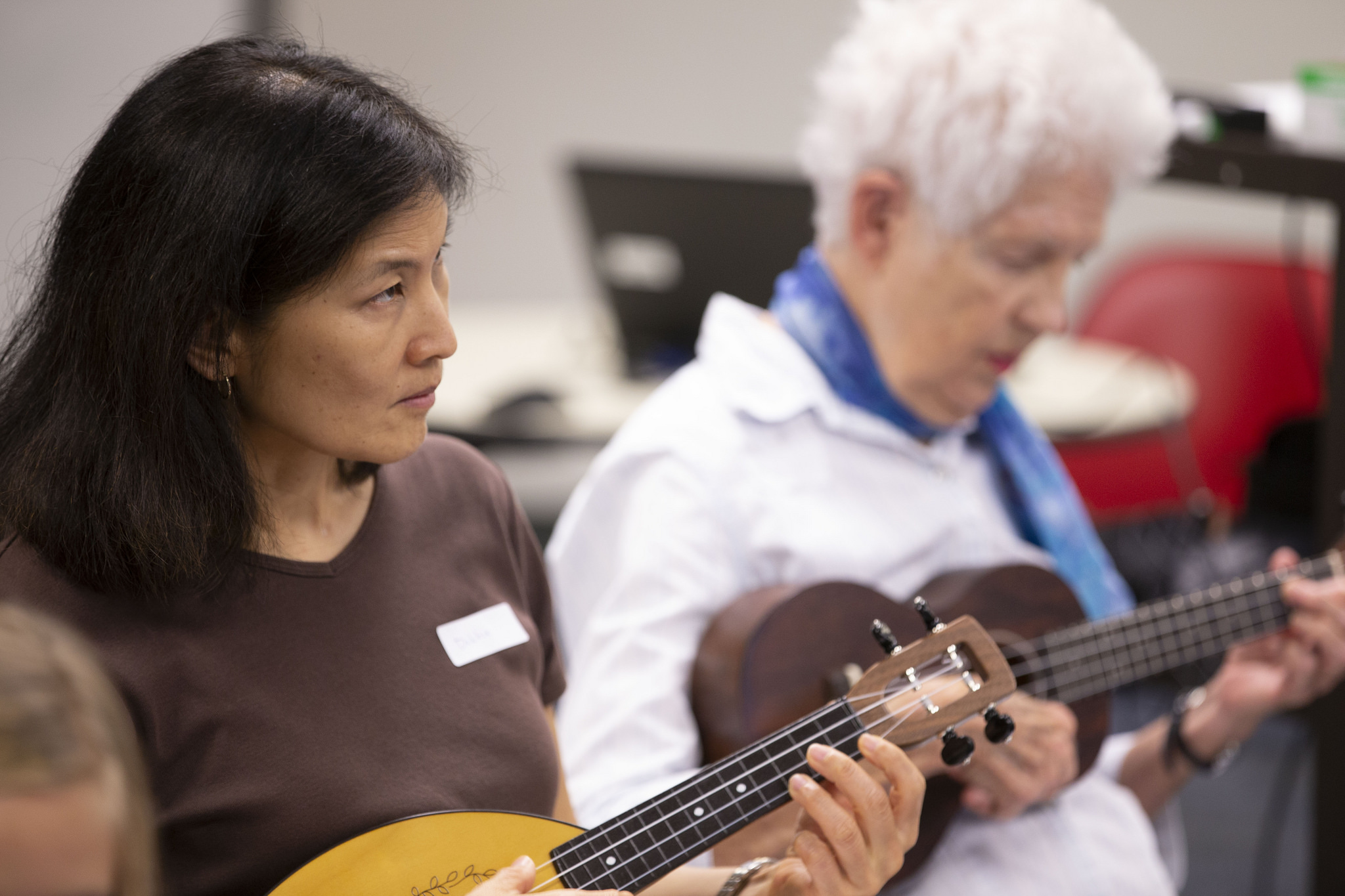 two women members play ukuleles