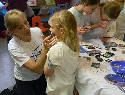 (Pictured: Samantha Norton of the Bloomsburg Theater Ensemble teaches a student how makeup is used to simulate a bruise in stage productions. Photo Courtesy of The Children’s Museum)