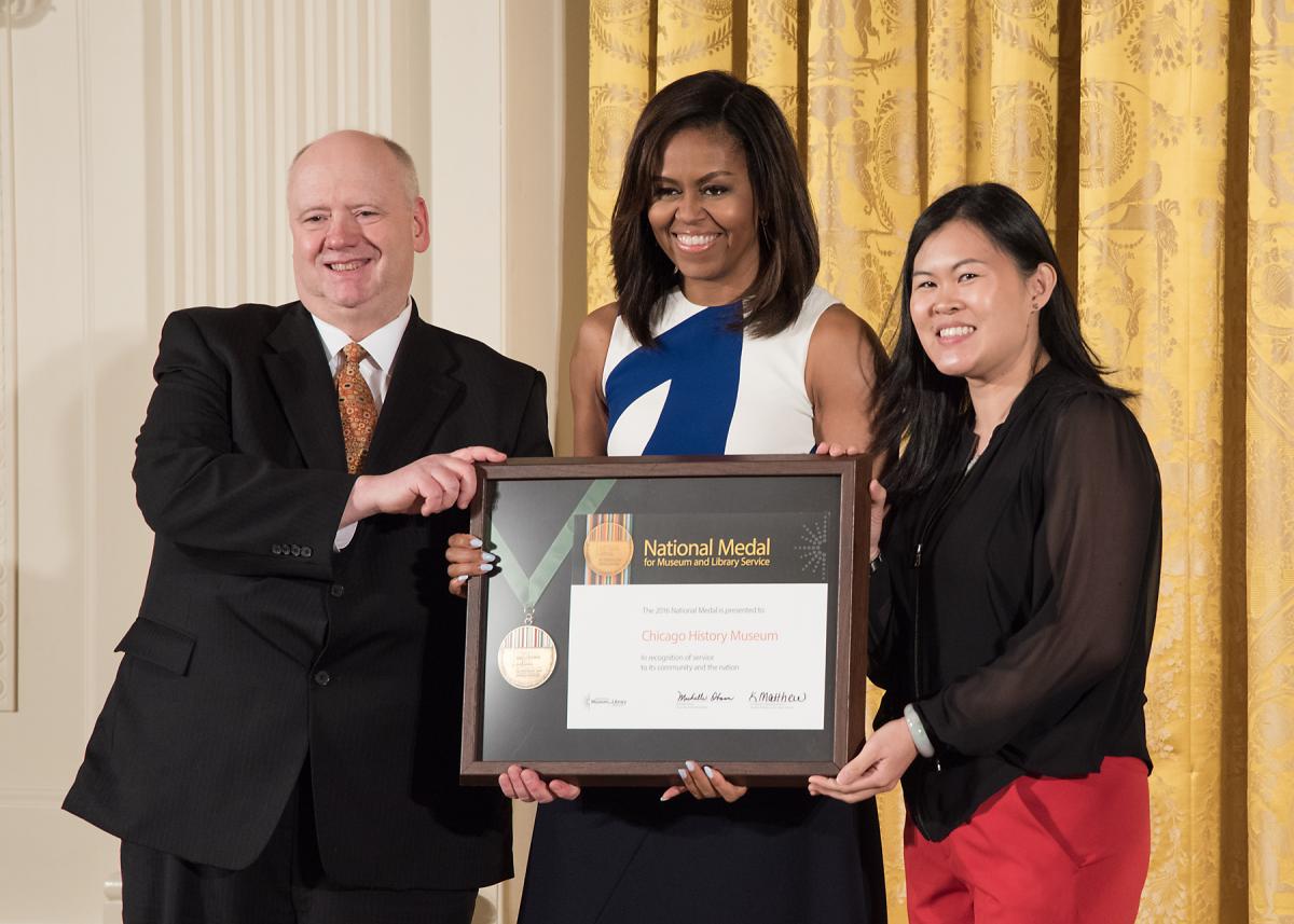 Representatives from the Chicago History Museum, President Gary T. Johnson and community member Joyce Chiu, accept the award from First Lady Michelle Obama. 