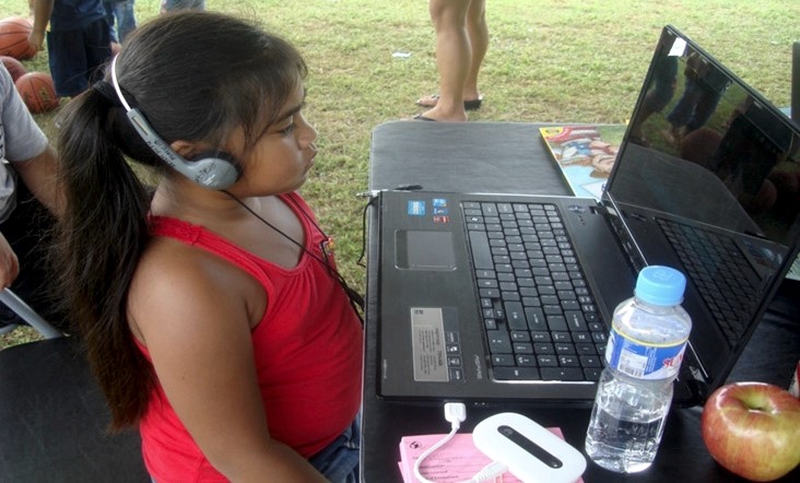 girl with headphones working on laptop