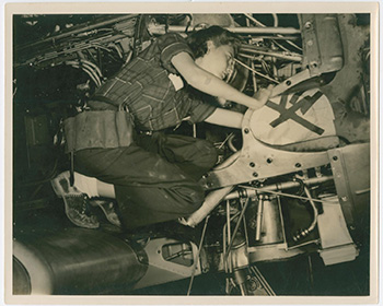 Woman working on the engine of a plane.
