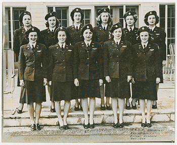 Group photograph of eleven WASP standing outside of a building at Napier Field.