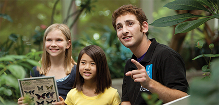 A staff member points out tropical butterflies at the Pacific Science Center in Seattle, WA.