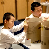 two boys decorate their drums