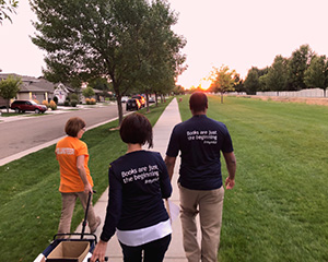 Three library volunteers walking outdoors.