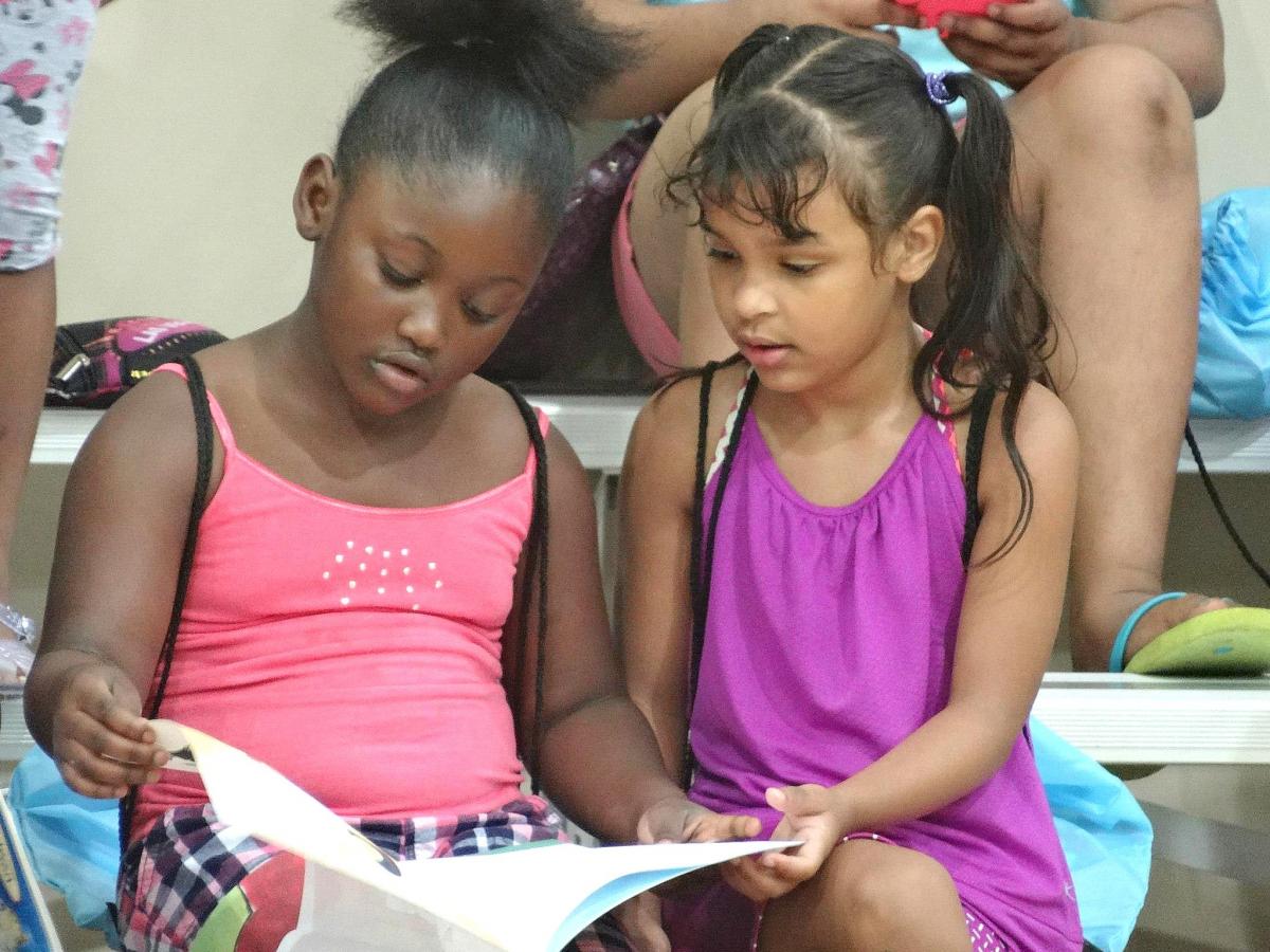 two young girls reading a book