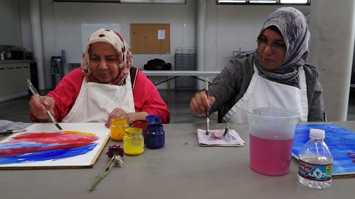 A mother and daughter work together on paintings during one of their art-making sessions.