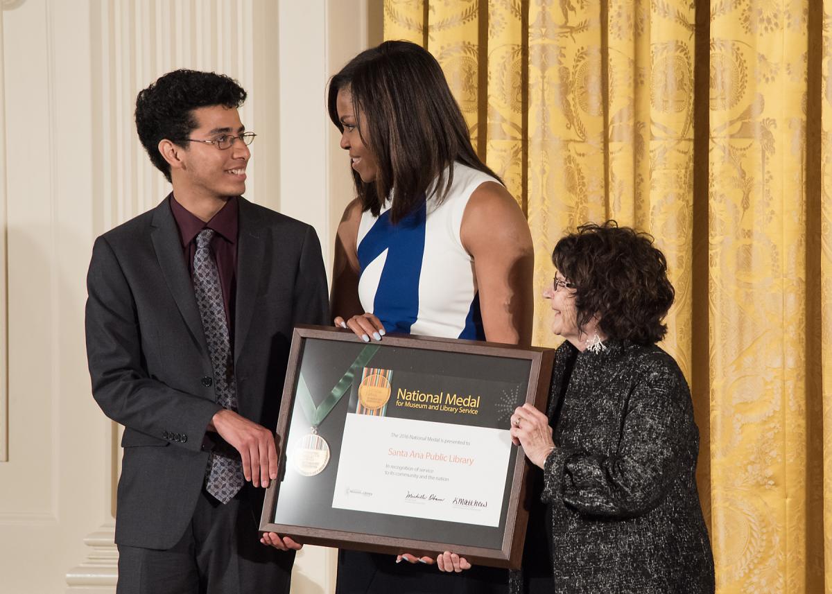 Community member Victor Gudiel and Santa Ana Public Library Director Heather Folmar accept the award from First Lady Michelle Obama during the ceremony. 