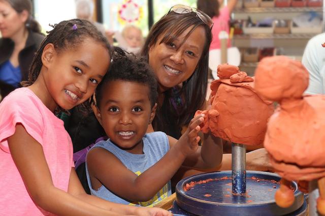 Museum visitors creating clay sculptures.