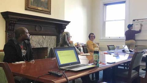 People sitting at a conference table inside Carnegie Library of Pittsburgh building.