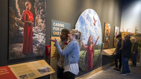 Museum patrons view painting of regal woman. MFA grantee MA-253392-OMS-23, Natural History Museum of the Adirondack