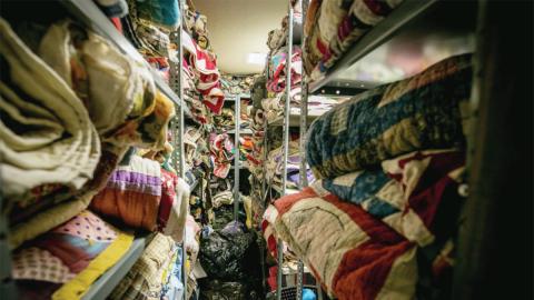 Quilts stacked on racks for conservation and protective storage