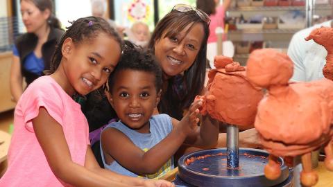 Museum visitors creating clay sculptures.